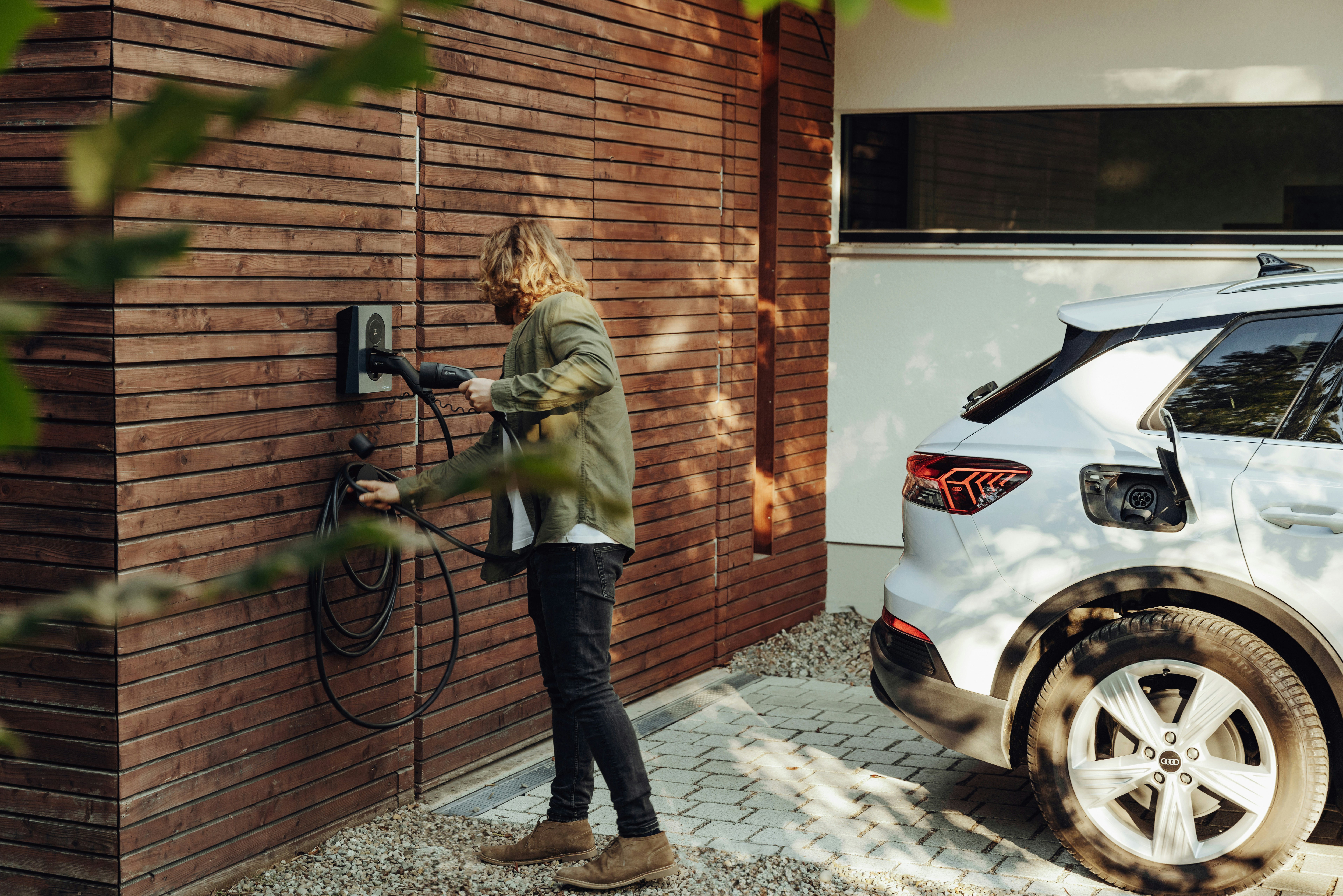 Illustration of a guest scanning a QR code at an EV charger to pay for electricity at a UK holiday let